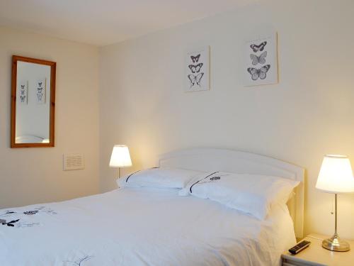 a bedroom with a large white bed with two lamps at Kirkview in Dundonald