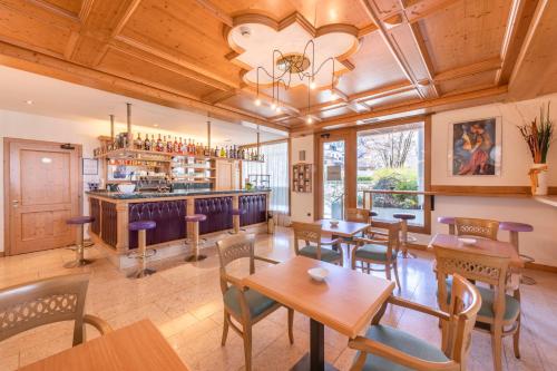 a restaurant with tables and chairs and a bar at Hotel Relais Orsingher in Fiera di Primiero