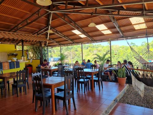 a restaurant with tables and chairs and people sitting at them at Cabinas Pura Vida B&B and Tour Operator in Drake