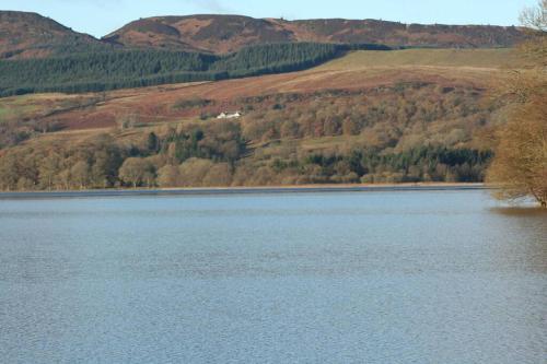 a large body of water with mountains in the background at The Mews - a cottage with a spectacular lake view in Port of Menteith