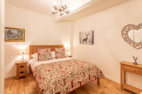 1 dormitorio con cama y espejo en la pared en The Mews - a cottage with a spectacular lake view, en Port of Menteith
