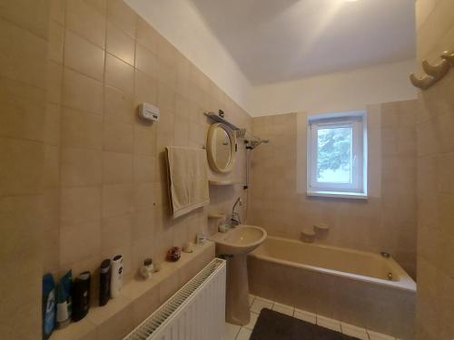 un bagno con un lavandino, una vasca da bagno e un lavandino di Sétány Apartmanház Fonyód a Fonyód