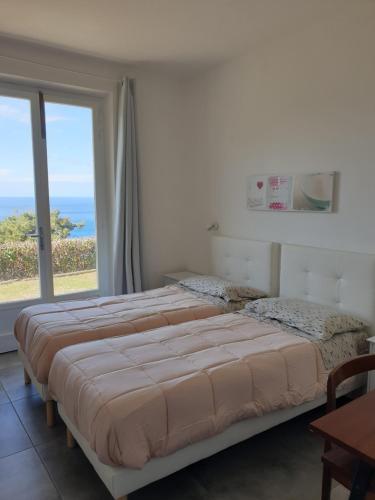 ein Schlafzimmer mit einem Bett und einem großen Fenster in der Unterkunft Alta Marina in Marciana Marina