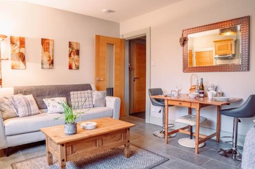 a living room with a couch and a table at Cottage Apartment in Dunblane