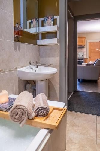 a bathroom with a sink and a counter with towels at Cottage Apartment in Dunblane