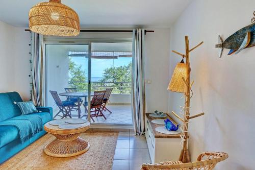 a living room with a blue couch and a table at Le Blue Lagoon - apt T2 Cap Homard in Grand Fond