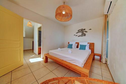 a bedroom with a bed with white sheets and blue pillows at Le Blue Lagoon - apt T2 Cap Homard in Grand Fond