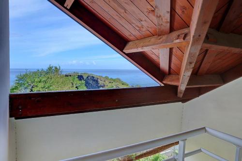 a view of the ocean from the roof of a house at Le Blue Lagoon - apt T2 Cap Homard in Grand Fond