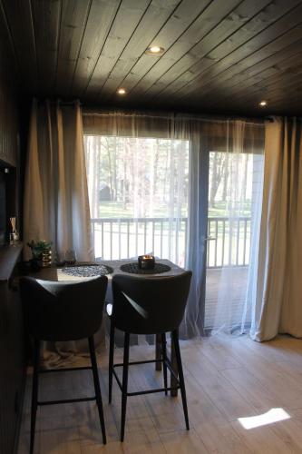 uma sala de jantar com uma mesa e cadeiras e uma janela em Little Amber em Bernāti