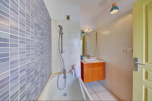 a bathroom with a tub and a sink at Le Blue Lagoon - apt T2 Cap Homard in Grand Fond