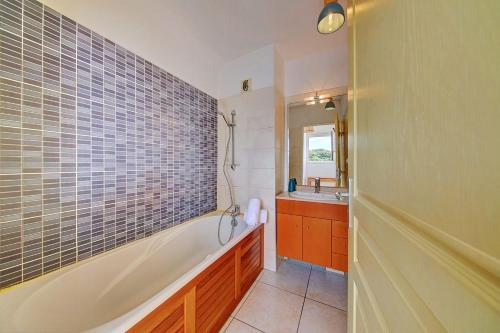 a bathroom with a tub and a sink at Le Blue Lagoon - apt T2 Cap Homard in Grand Fond