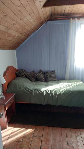 a bed in a room with a wooden ceiling at Los Laguitos in Santiago