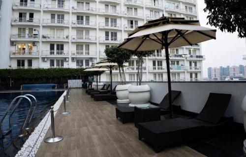 a balcony with chairs and an umbrella and a building at The Origin Suites DLF MY PAD in Lucknow