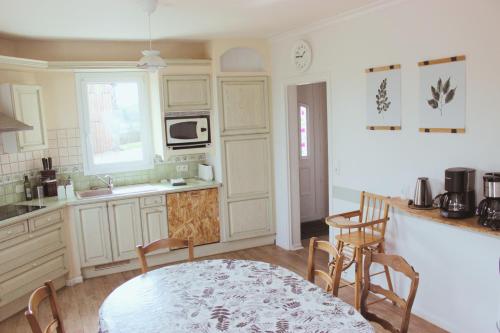 a kitchen with a table and chairs and a sink at Gîtes pour grand groupe 18 personnes à 15 mins du Puy du Fou in Mauléon