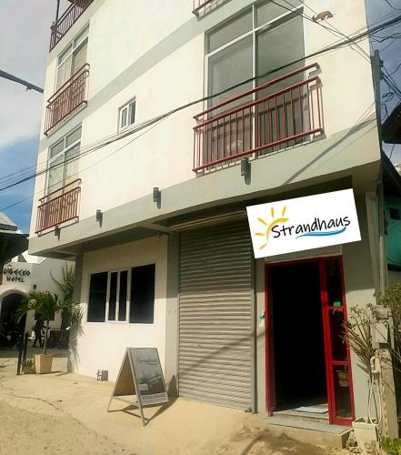 a building with a sign on the front of it at Strandhaus Condotel in Moalboal