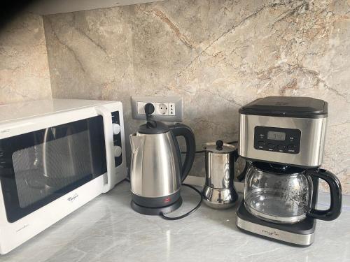 a kitchen counter with a coffee maker and a microwave at Apartament la Nicole ultracentral Bld Roman bloc 39 in Roman