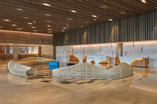a lobby with several metal furniture in a building at Courtyard by Marriott Melaka in Melaka