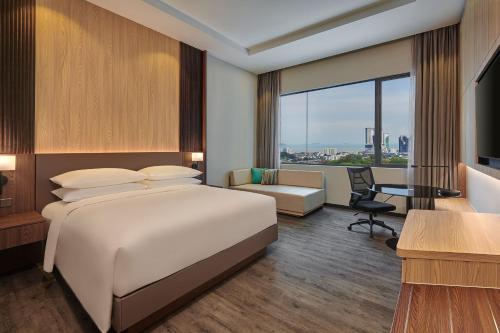 a hotel room with a bed and a desk at Courtyard by Marriott Melaka in Malacca