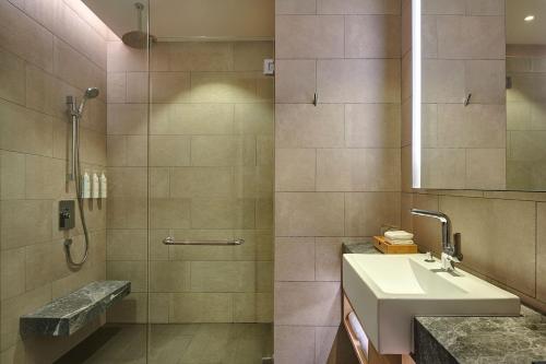 a bathroom with a sink and a shower at Courtyard by Marriott Melaka in Malacca