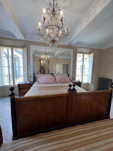 een grote slaapkamer met een groot bed en een kroonluchter bij Castiglione 27 Luxury Suite in Bologna