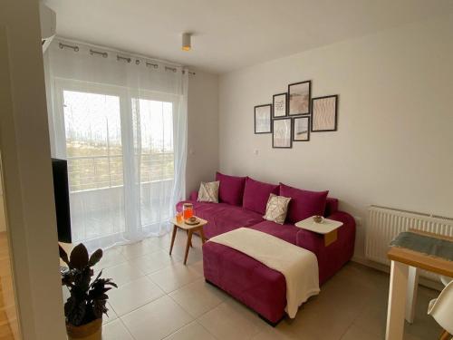 salon z czerwoną kanapą i oknem w obiekcie Portview apartment w mieście Rijeka