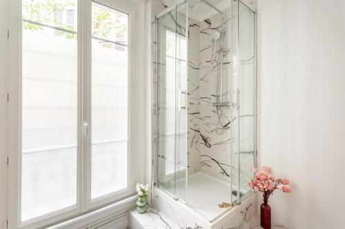 eine Glasdusche im Bad mit Fenster in der Unterkunft Cosy 3 bedrooms apartment - Le Marais in Paris