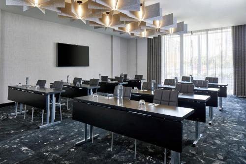 a conference room with tables and chairs and a flat screen tv at AC Hotel Miami Wynwood in Miami