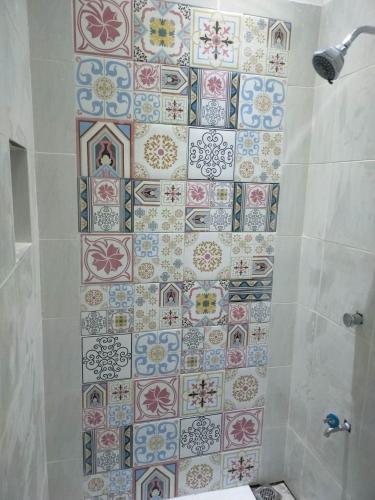 a bathroom with a tiled wall in a shower at FAST Wifi 400 Mbps Tiny House in Bacolod City in Bacolod