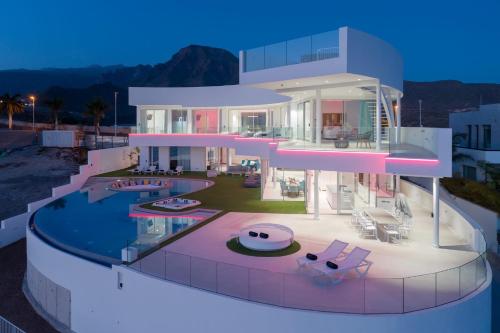 ein großes Haus mit einem Swimmingpool bei Nacht in der Unterkunft KARAT Villa Fibonacci in Adeje