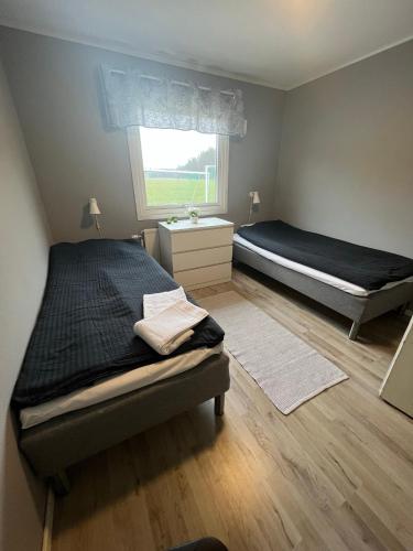 um quarto com 2 camas e uma janela em Traume vandrarhem em Visby