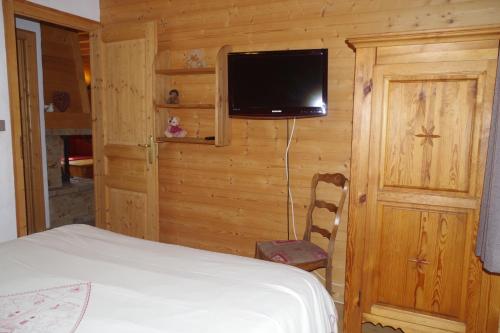 a bedroom with a bed and a tv on a wall at Chalet Le Sabot De Venus in Combloux