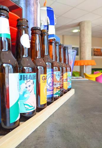 une rangée de bouteilles de bière assises sur une étagère dans l'établissement Auberge des Remparts, à Péronne