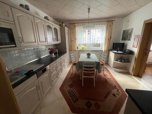 a kitchen with a table and a dining room at Ferienwohnung Beer in Fehrenbach