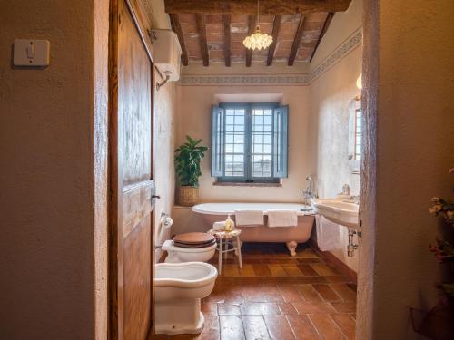 ein Badezimmer mit 2 WCs, einer Badewanne und einem Waschbecken in der Unterkunft Pieve Marsina & Borgo Argenina in Monti di Sotto