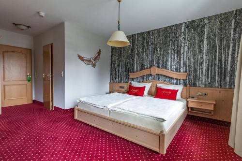 a bedroom with a bed and a red carpet at Landgasthof zum Mühlenteich in Eggersdorf