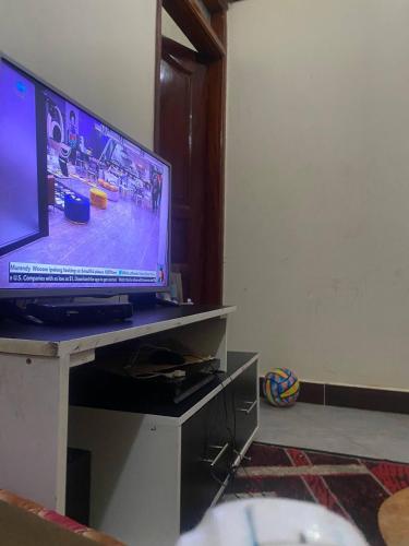 uma televisão sentada num centro de entretenimento com um tvictericter em Room in Guest room - Single Bedroom Sitting Room em Kampala