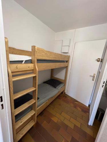 Łóżko piętrowe w niewielkim pokoju z szafą w obiekcie La Madrague w mieście Saint-Cyr-sur-Mer