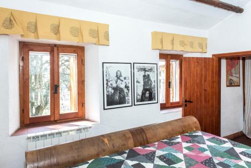 安科納的住宿－Casale della Luna，一间卧室设有一张床和两个窗户。