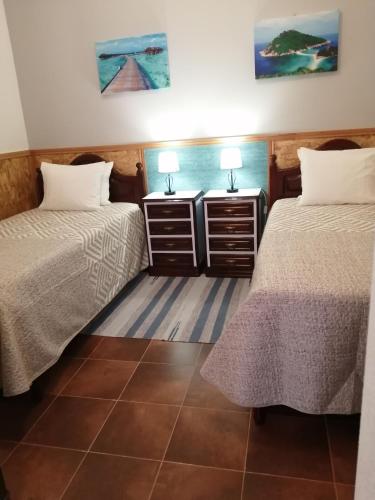 a room with two beds and two night stands at Casa Vaz 2 in Grândola