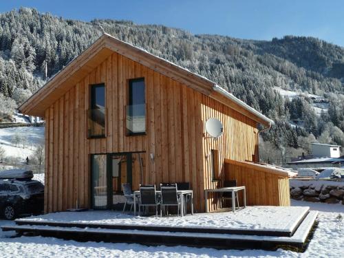 a wooden cabin with a table and chairs in the snow at Chalet Murau: Luxurious 5 star chalet in ski area Kreischberg in Murau
