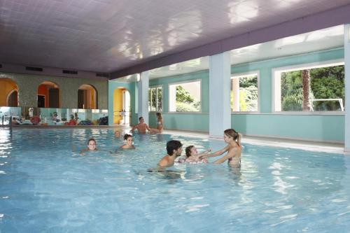 a group of children playing in a swimming pool at Hotel Castel Lodron in Storo