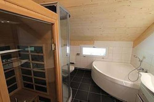 a bathroom with a tub and a shower and a sink at Chalet Murau: Luxurious 5 star chalet in ski area Kreischberg in Murau