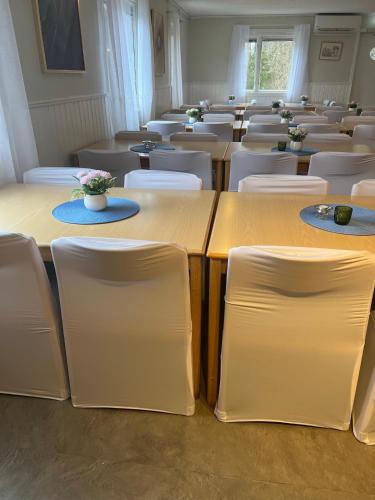 a room filled with tables and white chairs at Traume vandrarhem in Visby