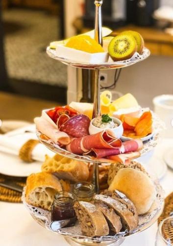a three tiered tray of food on a table at Mansion9Bruges in Bruges
