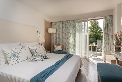 a bedroom with a bed and a large window at Minos Mare Royal in Platanes
