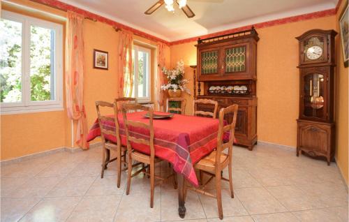 une salle à manger avec une table et des chaises rouges dans l'établissement Lovely Home In Les Salles Du Gardon, à Soustelle