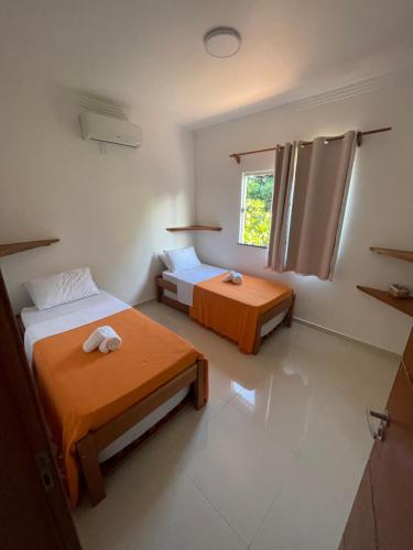 a room with two beds and a window at P&M'S Porto Seguro Taperapuan in Porto Seguro