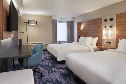 a hotel room with two beds and a desk at Fairfield by Marriott Niagara Falls, Canada in Niagara Falls