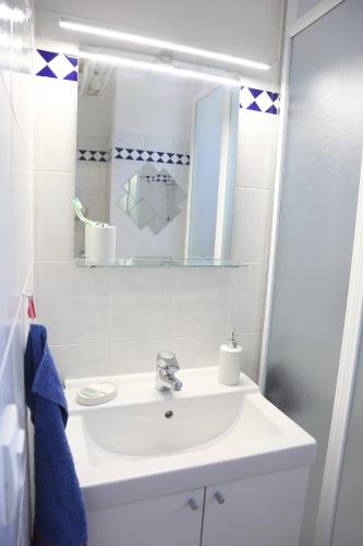 ein Badezimmer mit einem weißen Waschbecken und einem Spiegel in der Unterkunft Maldives YourHostHelper in Saint-Cyr-sur-Mer