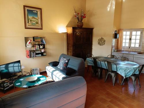 a living room with a couch and a table at Gîte du Cladan in LʼÉpine